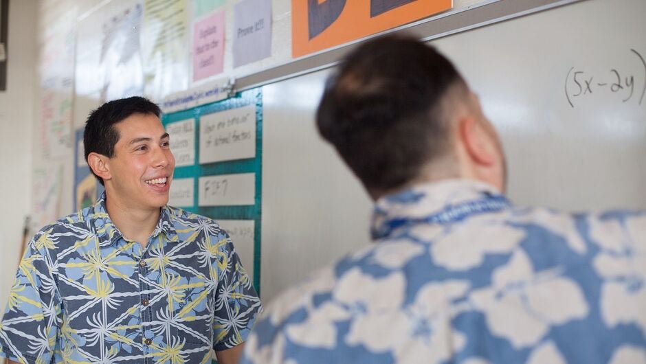 Two corps members in Hawaii collaborate at a white board.