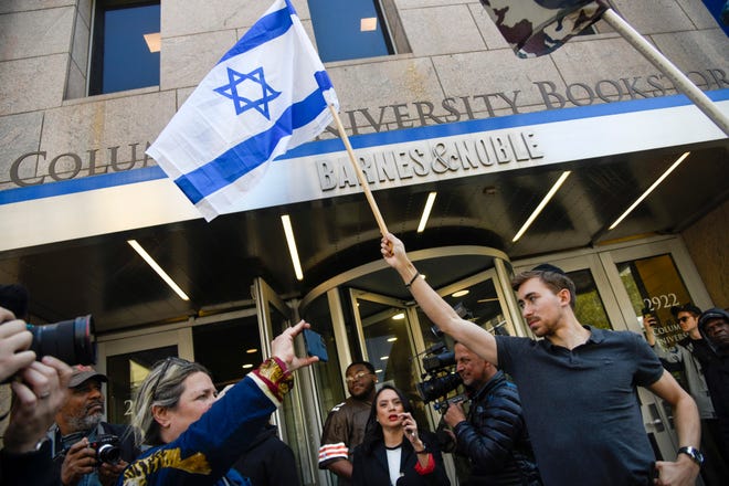 Protestors gather on the streets near the Columbia University campus in New York on April 22, 2024, after school officials closed the campus and made all classes remote. A few students holding Israeli flags to the cameras could be seen in the space.