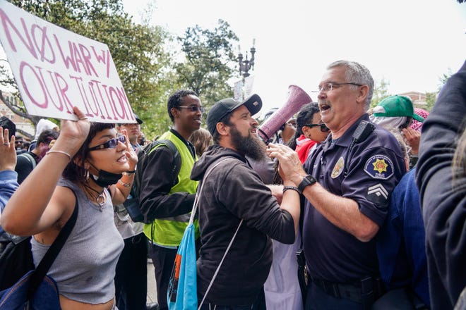 A protestor confronts a campus police officer during a demonstration at the University of Southern California, where several hundred people are protesting the ongoing war in Gaza. Protestors setup tents and signs in the early morning hours but campus security later cleared the gathering in Alumni Park. USC has been embroiled in controversy after canceling a pro-Palestinian valedictorian’s commencement speech.