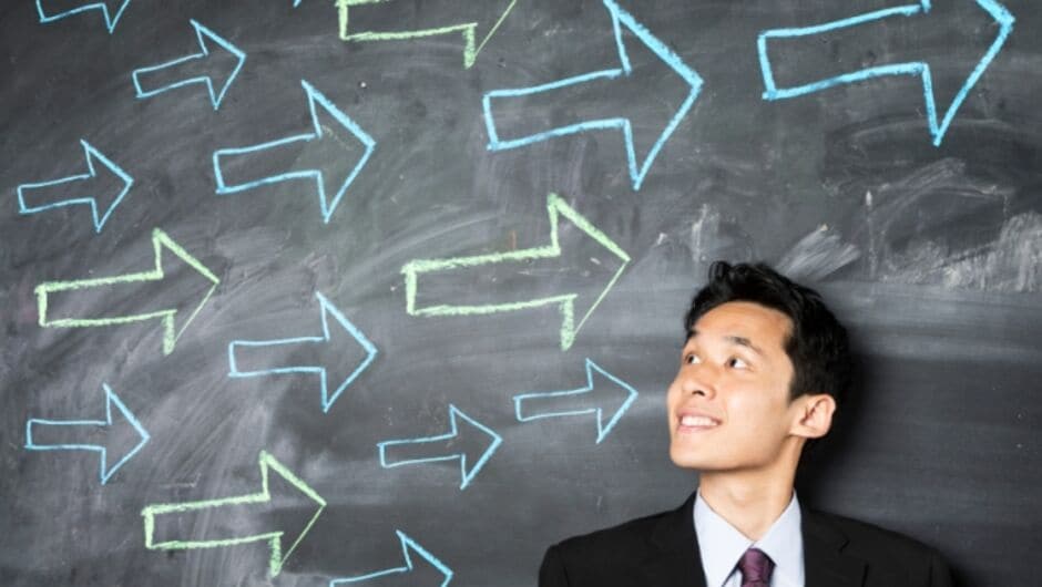 Man In Front of Chalkboard With Arrows